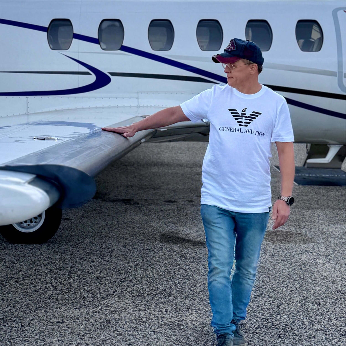 Person wearing a General Aviation T-shirt beside an airplane