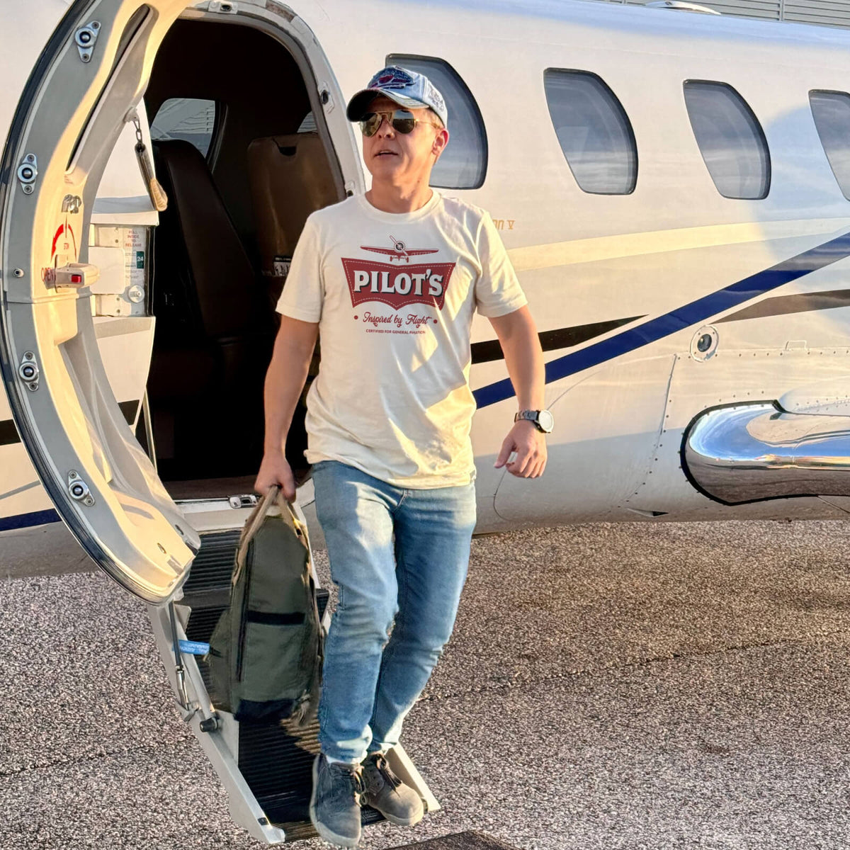 Person wearing a Pilot’s aviation T-shirt beside an airplane