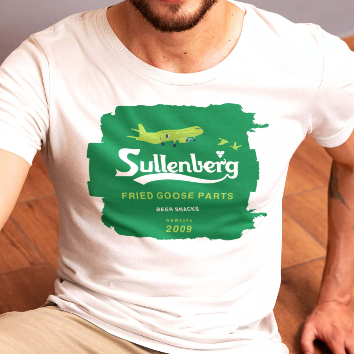 Close-up of the green Sullenberg design on a white T-shirt
