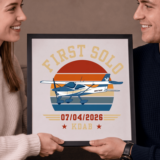 Close-up of a couple holding a black-framed first solo aircraft print