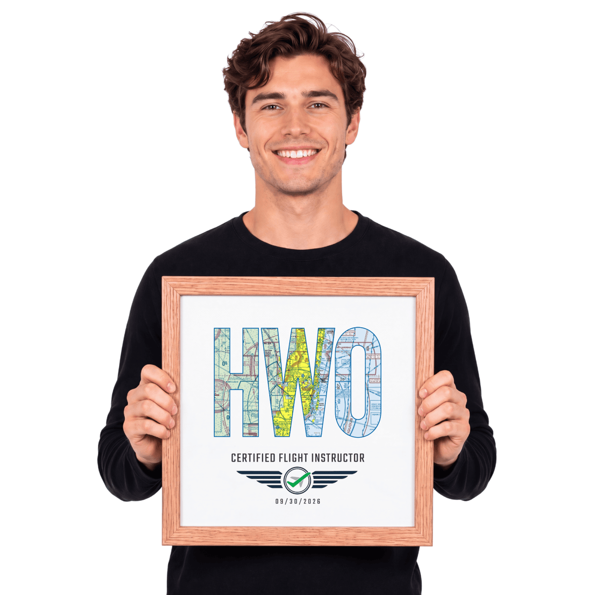 Man holding a wood-framed HWO airport code print celebrating a certified flight instructor milestone