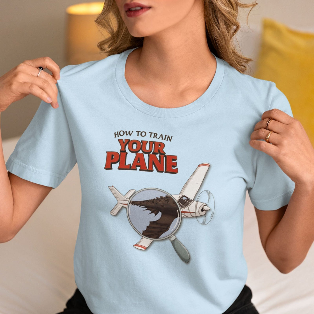 Woman wearing a blue How to Train Your Plane T-shirt