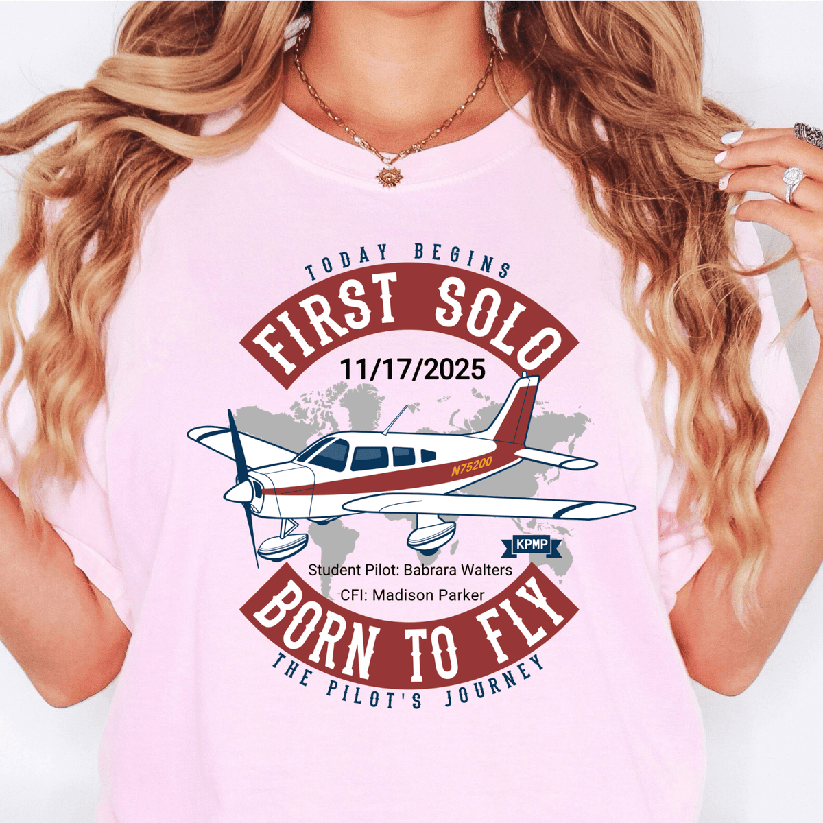 Woman wearing a pink First Solo T-shirt with an aircraft illustration and red Born to Fly lettering