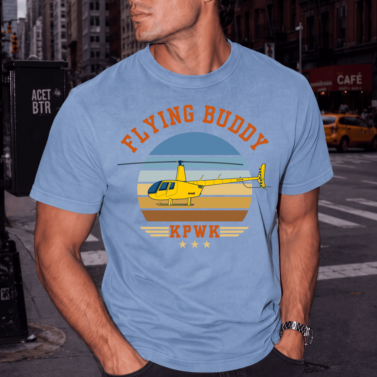 Man wearing a light blue Flying Buddy T-shirt with a yellow helicopter and KPWK airport code