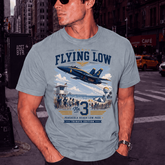 Man wearing a blue Flying Low Pensacola Beach aviation T-shirt