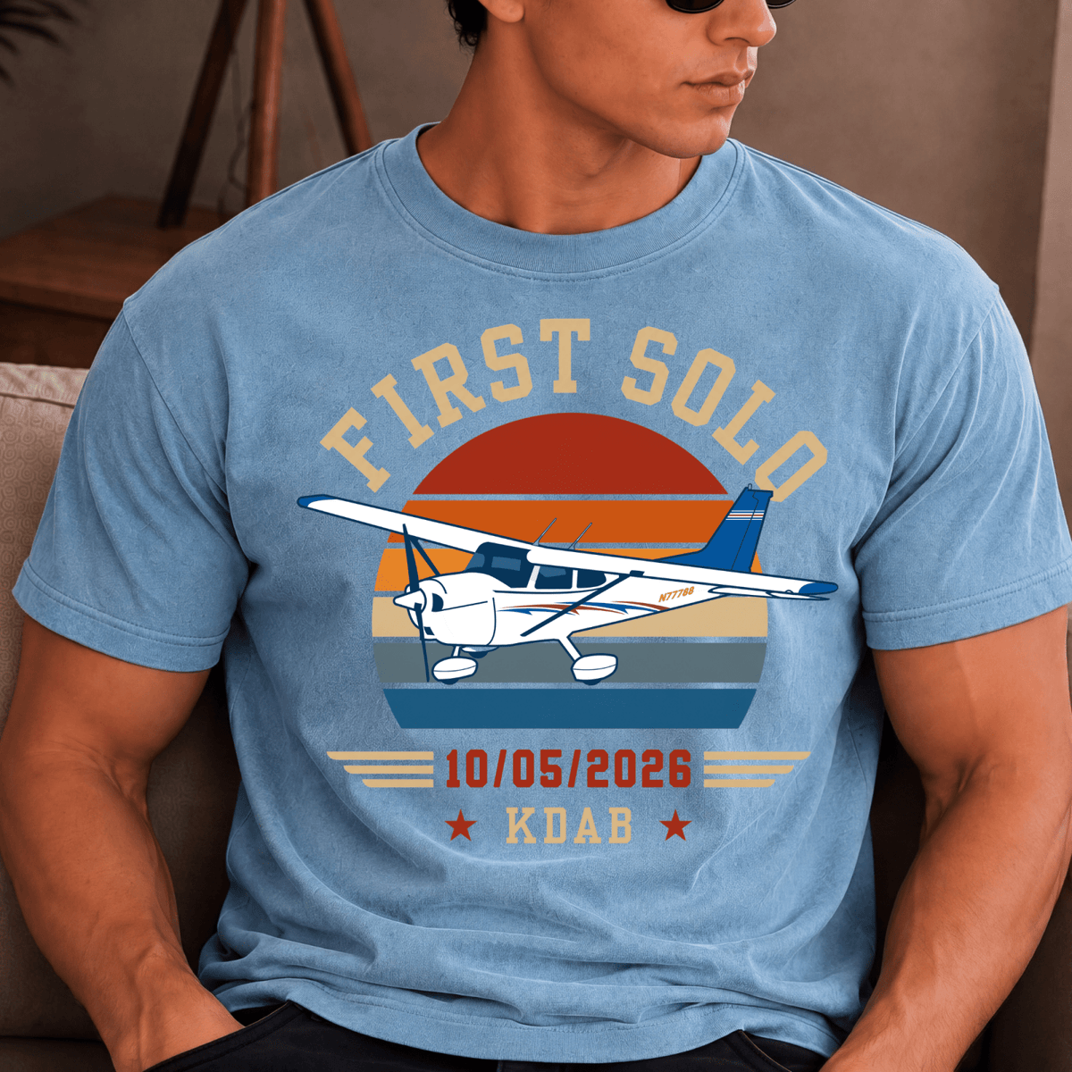Man wearing a blue First Solo T-shirt with a high-wing airplane and personalized flight details