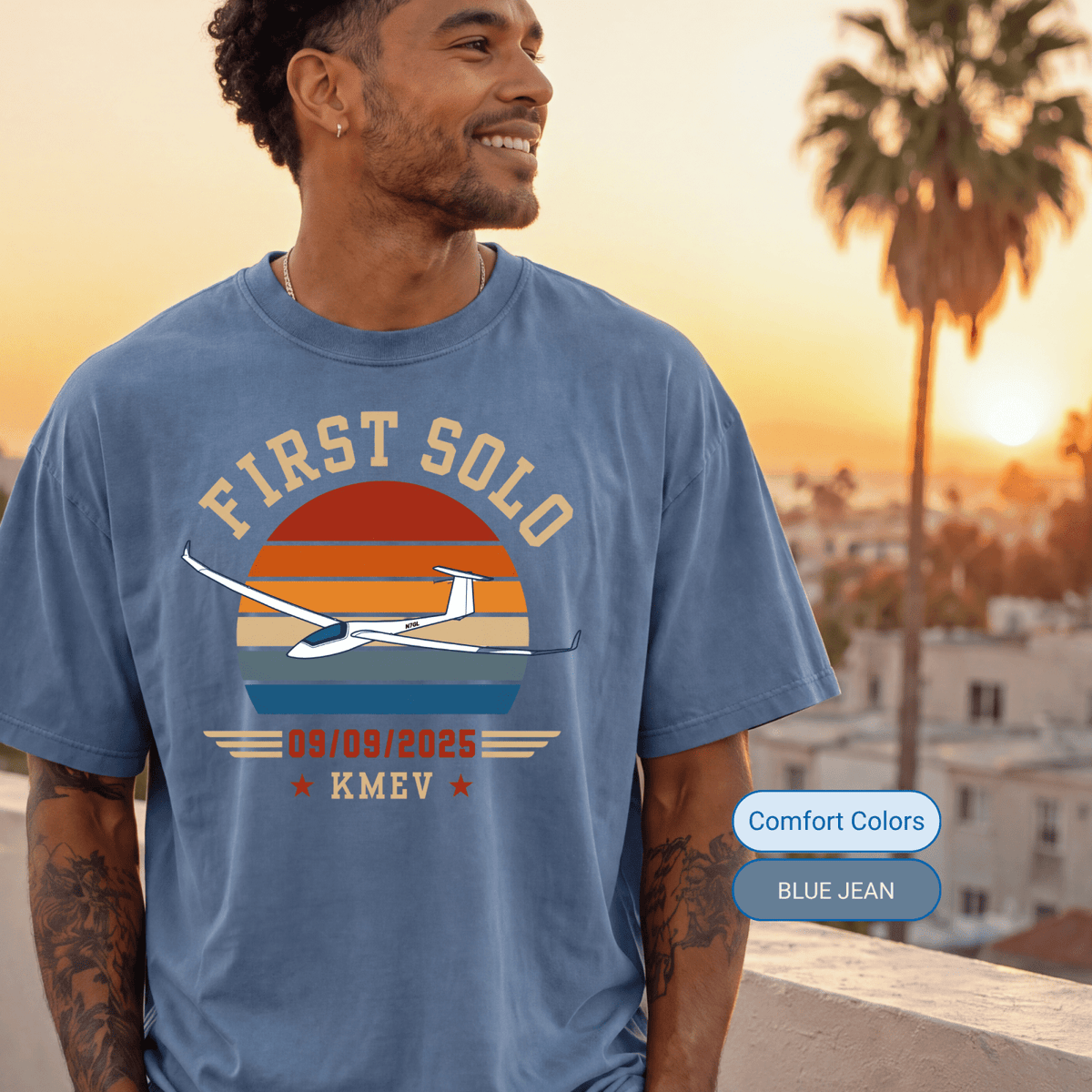 Man wearing a Blue Jean Comfort Colors First Solo T-shirt with a glider and retro sunset design