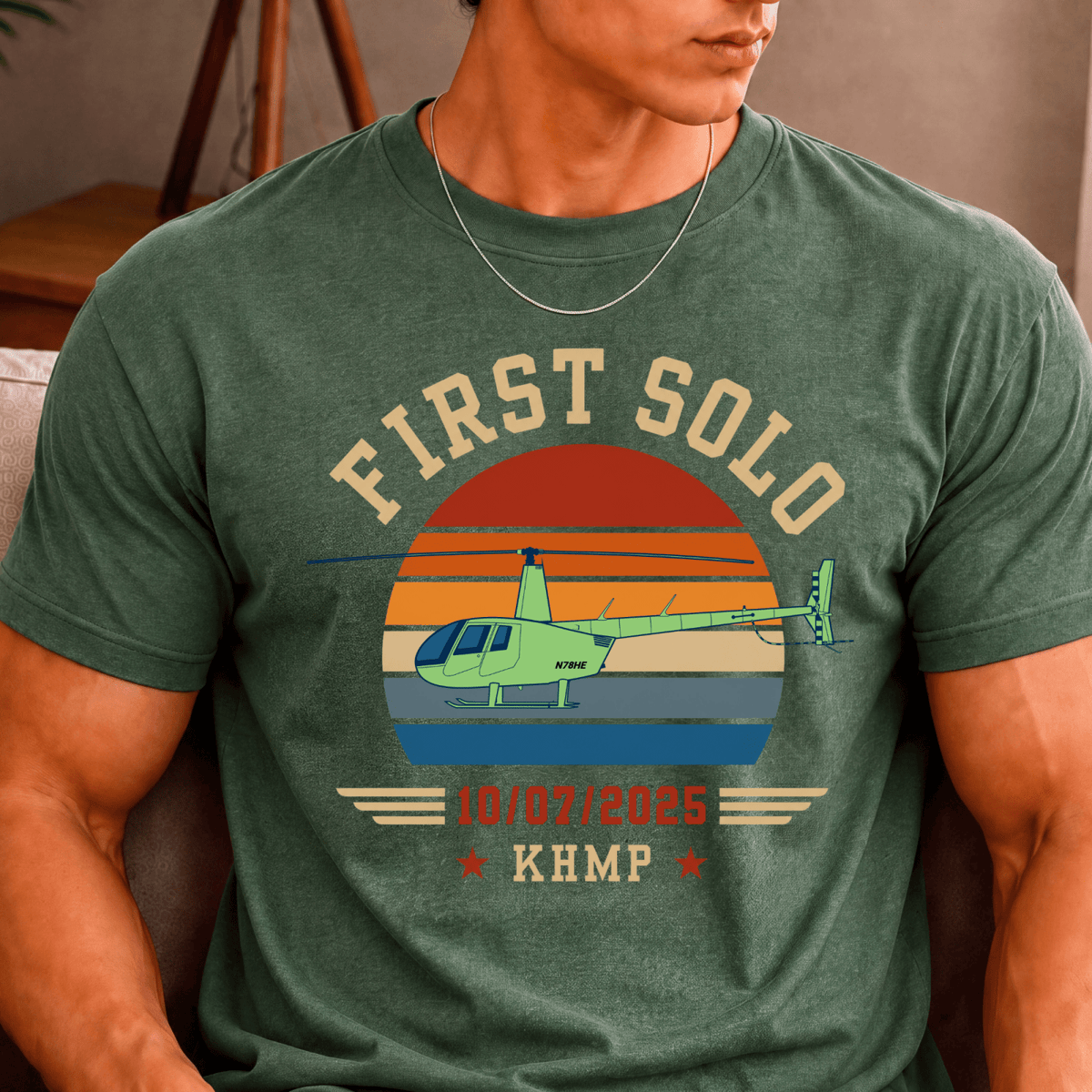Man wearing a green First Solo T-shirt with a helicopter illustration and personalized flight details