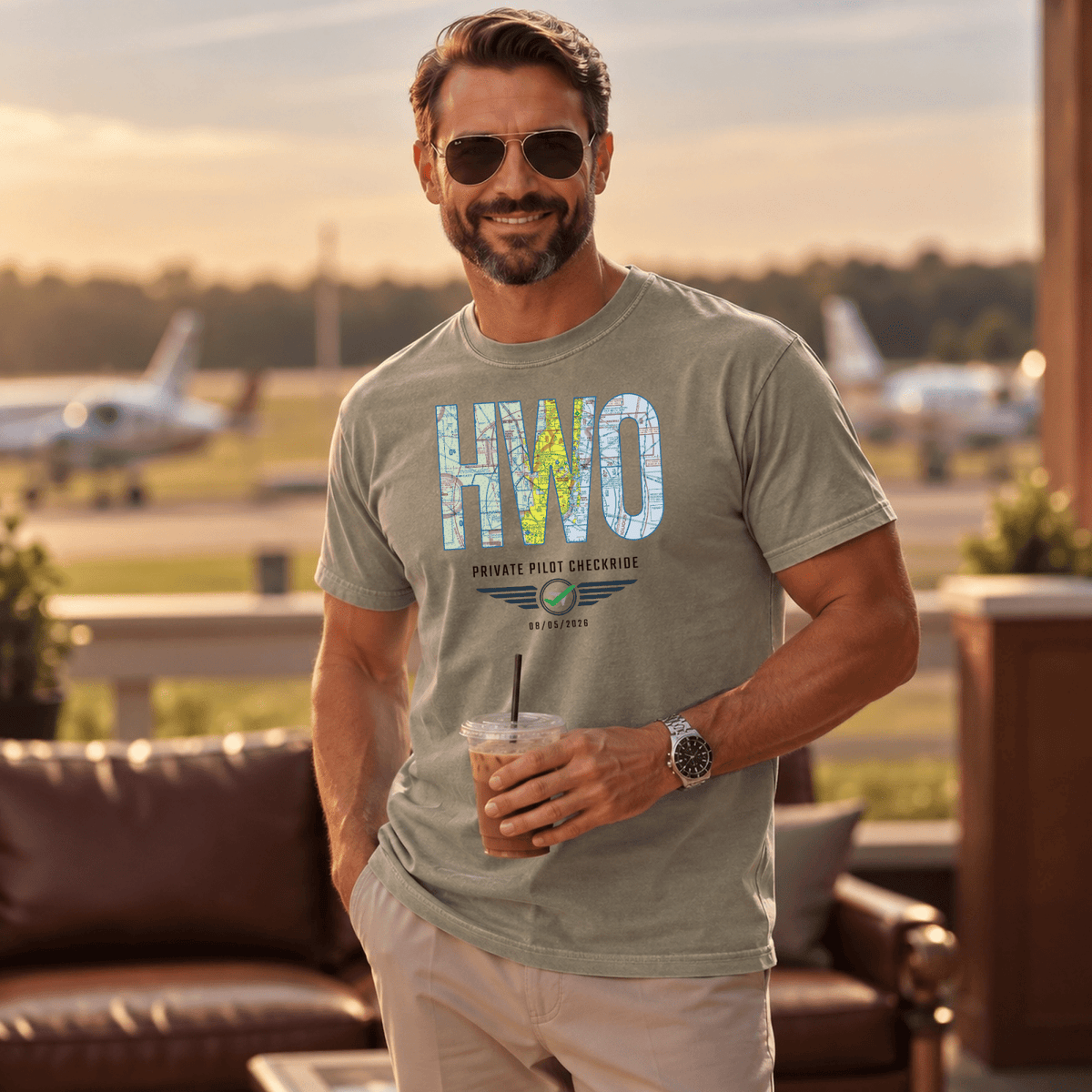 Man wearing a gray-green HWO airport code VFR chart T-shirt at an airfield