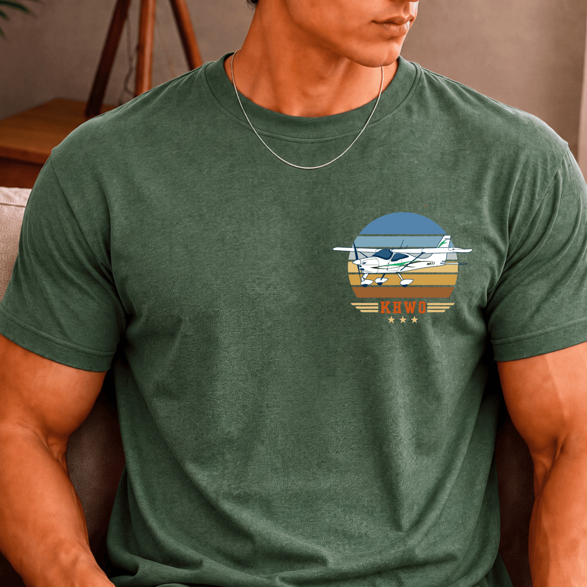 Man wearing a green Vintage Attitude pilot T-shirt with a high-wing airplane chest design
