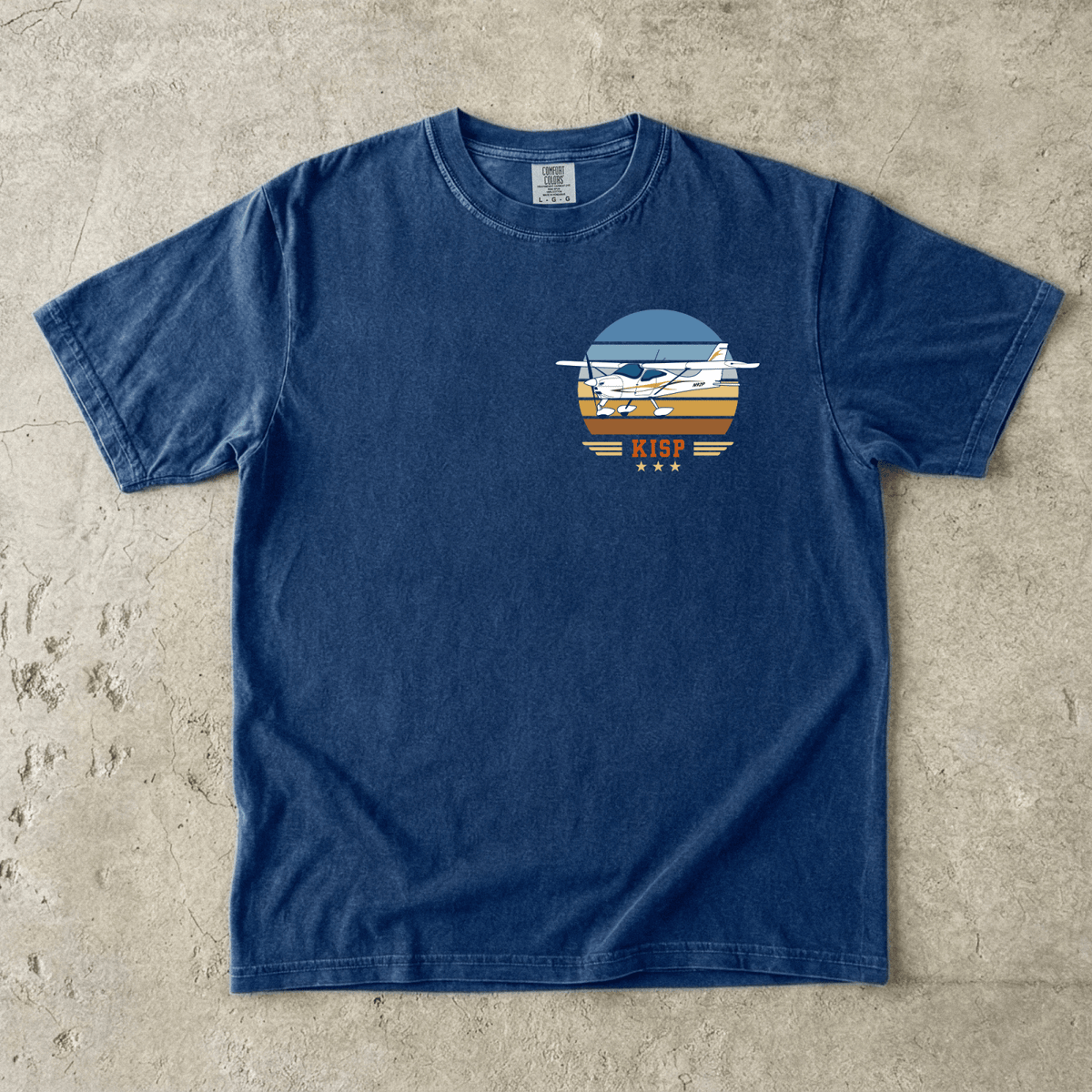 Navy Vintage Attitude T-shirt laid flat with a high-wing airplane and KISP airport code