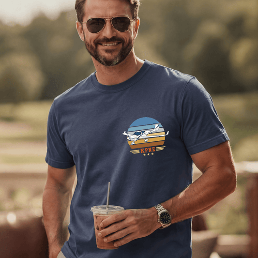 Man wearing a navy Vintage Attitude pilot T-shirt with a small aircraft and retro striped chest design